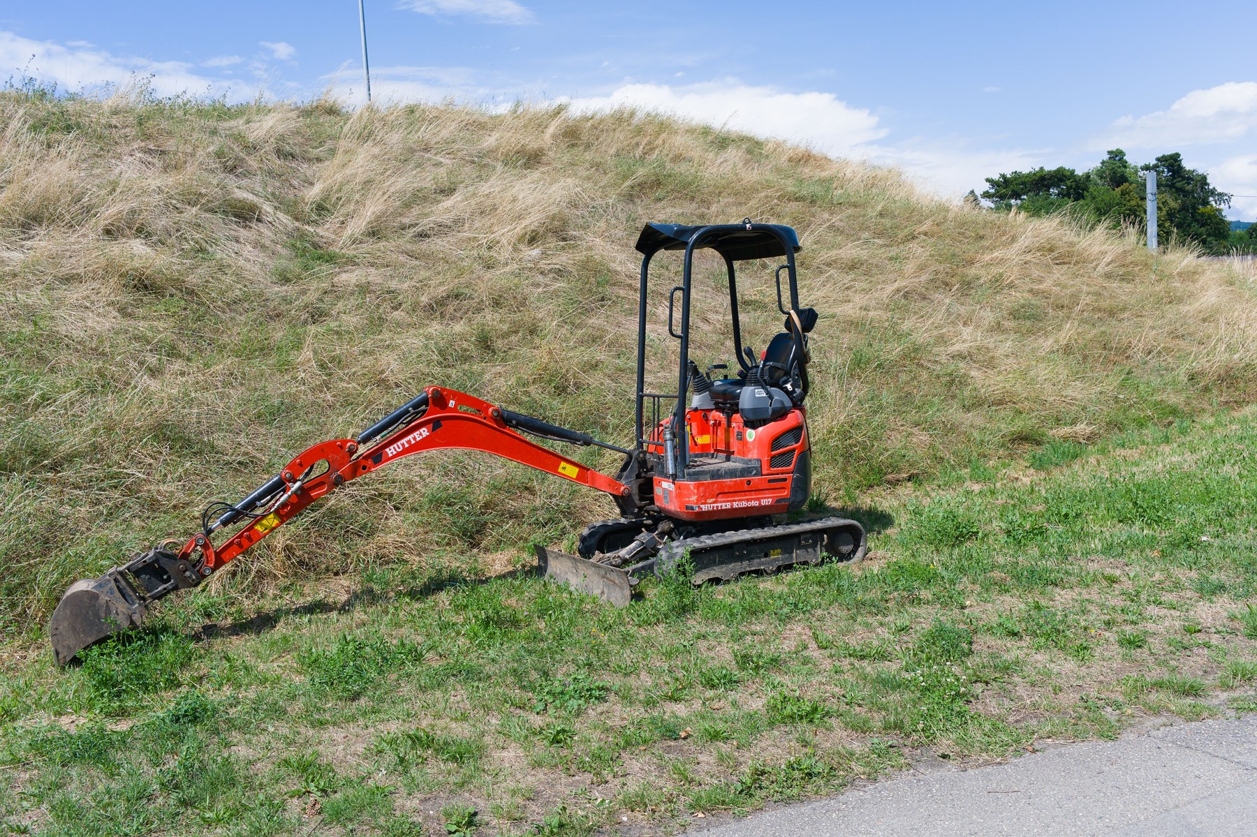 Roter Minibagger auf einer Grünfläche